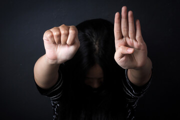 Woman Showing Signal For Help Or SOS Gesture Over Dark Grey Background