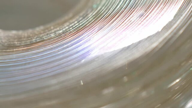 Abstract close up of layered iridescent metallic rings, showing depth and reflective light play, creating a subtle, modern shimmering design.