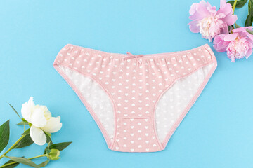 Pink cotton women's panties on the blue background.