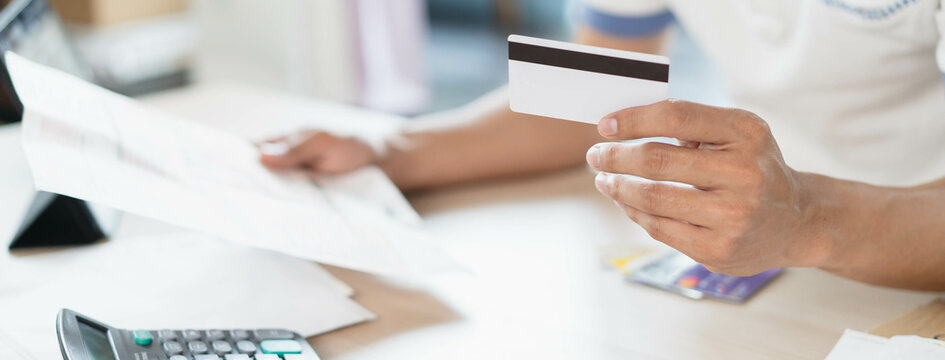 Close up person calculating monthly expense and credit card debt.