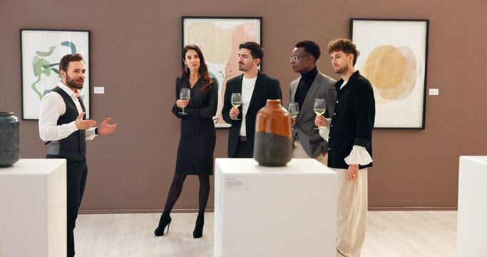 Man, explain and people with champagne at gallery for event, audience chat and talking for auction. Curator, customer and alcohol for discussion, artwork collection and art presentation of exhibition