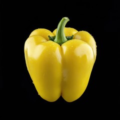 A vibrant, glistening yellow bell pepper, water droplets visible, set against a stark black background
