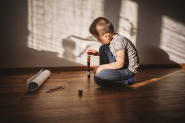 child builds  tower, constructor, puts things in order
Little boy lonely depressed standing with...
