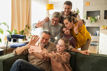 Family taking a selfie during a reunion in the living room with smiling faces and homemade dishes