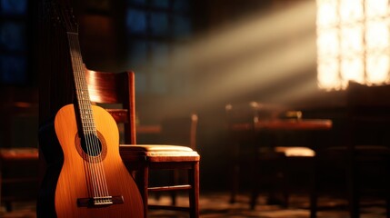 Acoustic guitar leaning against a chair in a dimly lit room with sunlight streaming through a window