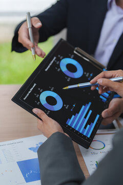Business people analyzing financial charts and data on tablet