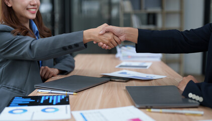 Businesspeople shaking hands after successful meeting in office boardroom