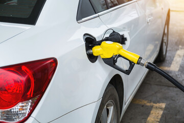Closeup fuel dispenser gasoline fuel in car at gas station. Petrol or gasoline being pumped into a...