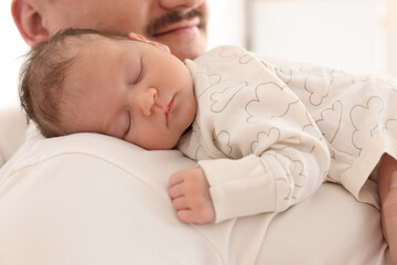 Father with his cute newborn baby indoors, closeup