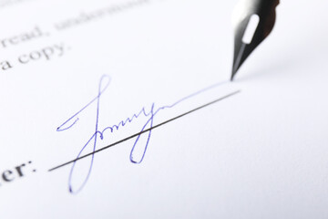 Fountain pen leaving signature on contract, closeup
