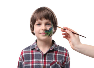 Animator drawing dinosaur on boy's face against white background, closeup
