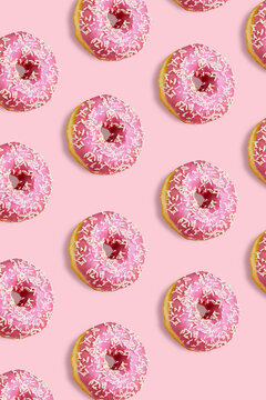 Pink donuts isolated on pink background. Hard shadow