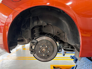 A car's brake assembly is under inspection at an auto repair facility. The technician assesses the...