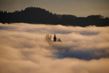 St.Thomas church in morning fog near Skofja Loka in Slovenia
