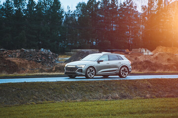 Modern SUV driving along rural road with green scenery