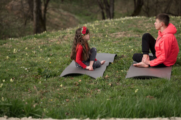 Outdoor yoga practice brings peace and connection between a child and an adult surrounded by nature...