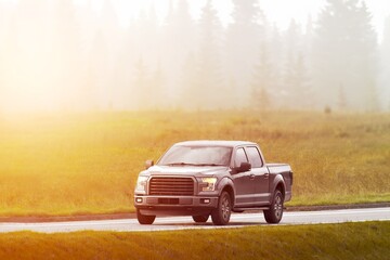 Fototapeta premium Misty rural road drive with pickup truck