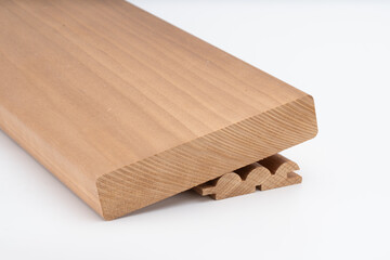 Close-up of a machined wooden panel or stair tread with precise grooving and curved detailing, isolated on a white background for product display..