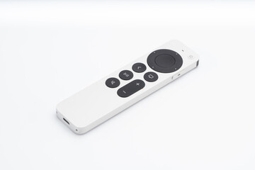 White smart TV remote control with black buttons placed on a clean white background, shown at an angle for clear visibility of design and features..