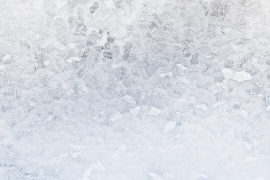 white winter background, frosty patterns on glass, abstract backdrop of ice and snow crystals in a blur