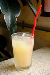 Grapefruit juice in a glass with a red straw