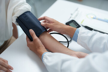 Medical professional checking patient's blood pressure