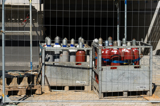 Industrial gas cylinders stored in fenced area during construction