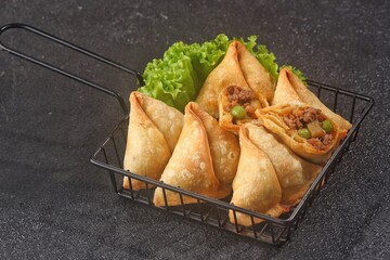 Samosa or samboosa is a triangular fried pastry filled with boiled potatoes seasoned with spices mixed with peas, onions, coriander leaves, and sometimes paneer.