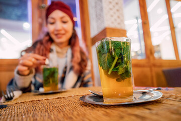 Tourist enjoying a glass of moroccan tea with mint sitting at a table in a traditional restaurant in Marrakech