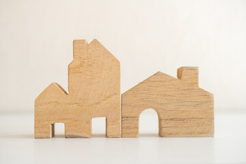Minimalist wooden house model placed on a clean white surface