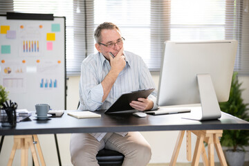 Naklejka premium A businessman is sitting at his desk working.