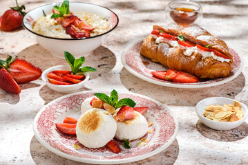 cottage cheese cheesecakes with strawberries, croissant and porridge with strawberries. breakfast in the restaurant