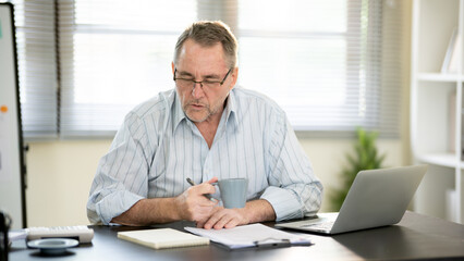 Fototapeta premium A businessman is sitting at his desk working.