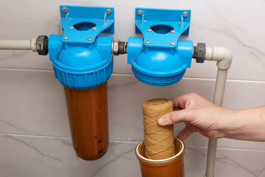 Replacing the water purification filter in a home filtration system.