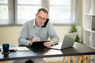 Naklejka premium A businessman is sitting at his desk working.