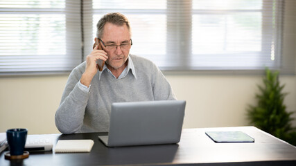 Obraz premium A businessman is sitting at his desk working.