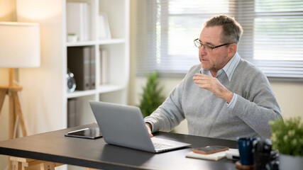 Fototapeta premium Businessman discussing work via video conference at his desk.