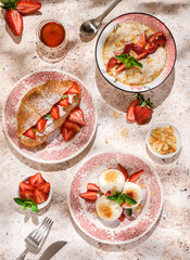 cottage cheese cheesecakes with strawberries, croissant and porridge with strawberries. breakfast in the restaurant