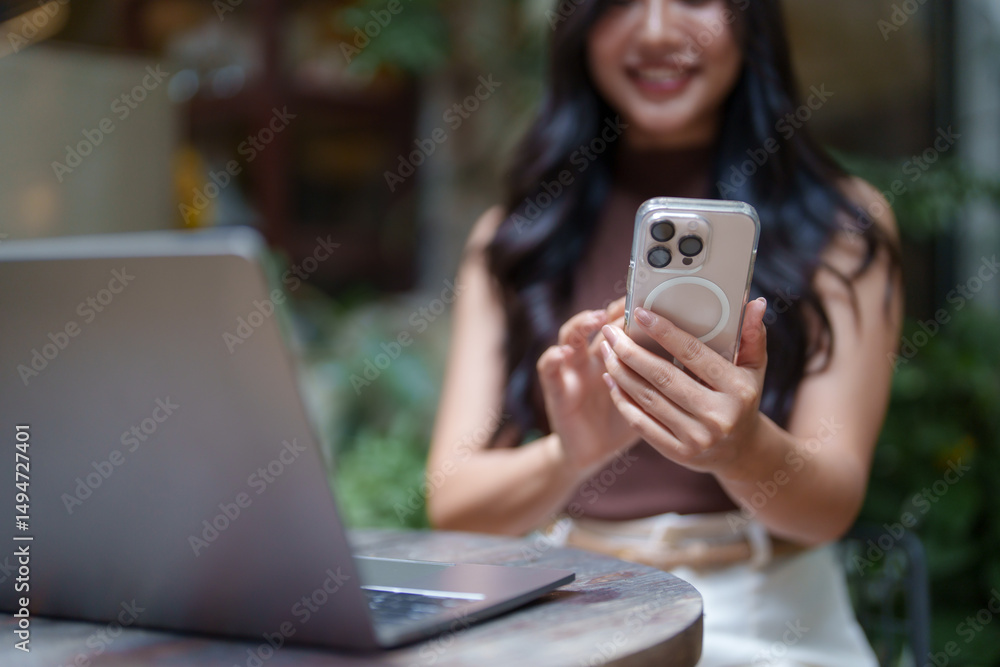 Poster freelancer working remotely using smartphone and laptop in cafe