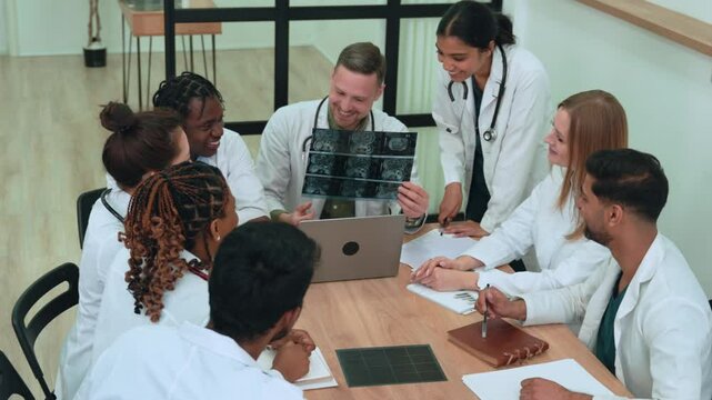 Diverse healthcare team analyzing brain imaging, sharing medical insights, collaborating on complex diagnostic review and potential treatment strategy