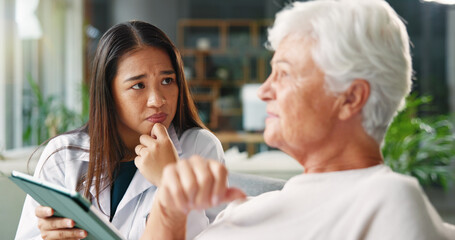 Doctor, senior woman and tablet with worry on sofa for report, assessment and discussion in retirement. Elderly person, caregiver and touchscreen with talking, listening and stress at nursing home
