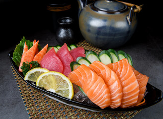 Assorted sashimi platter with salmon, tuna, kani, cucumber, and lemon