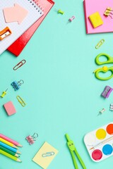 A vertical collection of brightly colored school supplies including notebook, stationery, displayed...