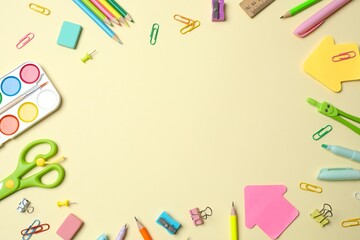 School supplies creatively arranged on a color surface, including paints, scissors and pencils