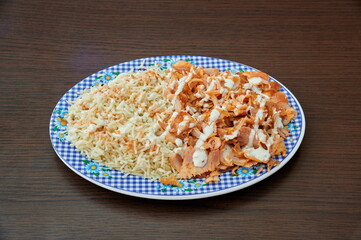 A plate of food with rice and meat on it. The rice is white and the meat is brown