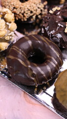 various kinds of chocolate donuts with various topping variants. in the photo with a 45 degree angle, front view and flat lay