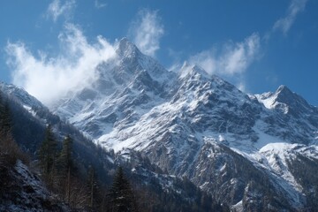 Obraz premium Snow-covered mountain peaks rise majestically under a clear blue sky during a bright winter day in a serene landscape