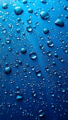 Blue background adorned with numerous glistening water  droplets of varying sizes. 
