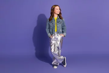 Vitrage gordijnen Stylish young girl in trendy attire smiling confidently against a vibrant purple background © deagreez