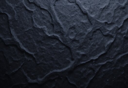 Close up detailed texture of dark natural stone surface with intricate patterns and rugged look